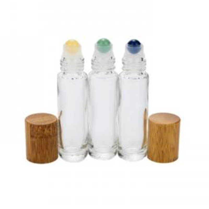 three glass tubes with roller tops and two gold covers