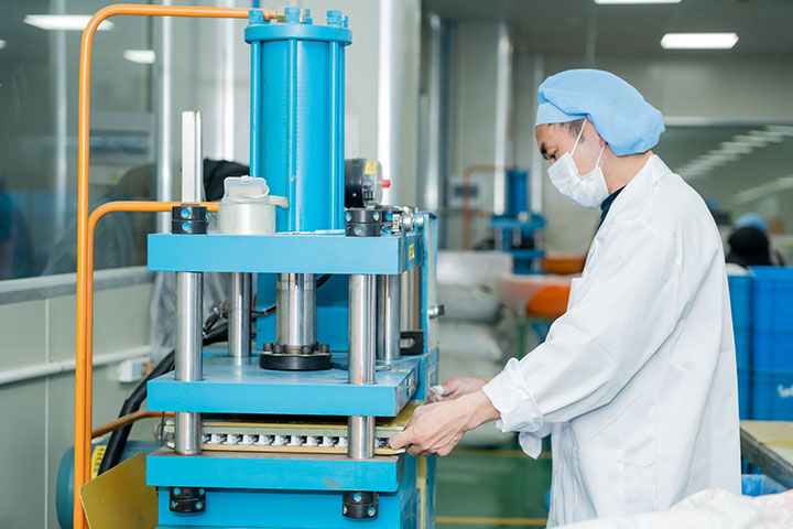 man in front of a vial making machine